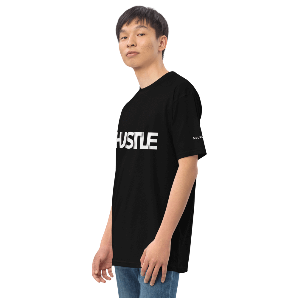 Stylish model wearing black Essential Hustle Tee with 'HUSTLE' text, showcasing its comfortable fit and modern design.
