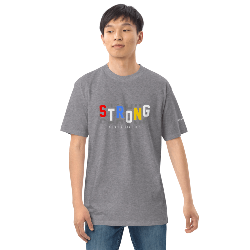 Model wearing gray Essential Strong Tee with colorful 'STRONG' print and 'NEVER GIVE UP' slogan.